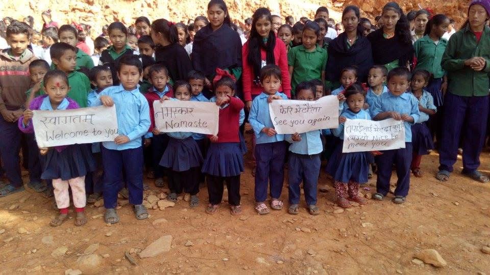 A mentor sitting with Nepali students during a study session